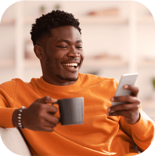 Um rapaz tomando café acessando seu celular