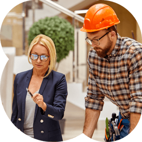 Homem e mulher fazendo calculo olhando a planta da construção