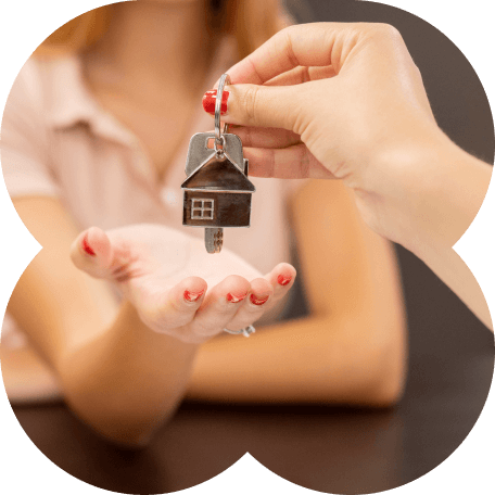 Uma mão prestes a segurar a chave de sua casa própria